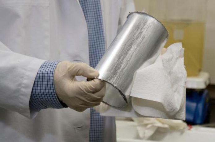 A photo of a worker wiping a metal cylinder after its been cleaned after aqueous cleaning